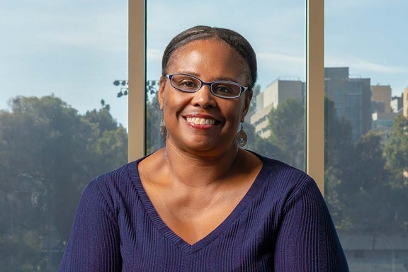 A portrait of Nicole Presley, wearing glasses and a navy blue top.