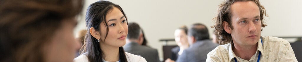 A shallow depth-of-field shot capturing the concentrated expressions of participants during a seminar.